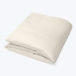 Folded cotton duvet cover in pale beige, neatly arranged fabric.