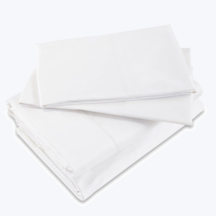 Crisp, white bed sheets neatly stacked in minimalist setting.