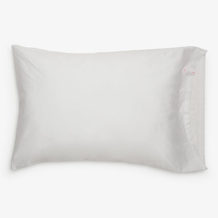 Freshly fluffed white rectangular pillow with minimal design.