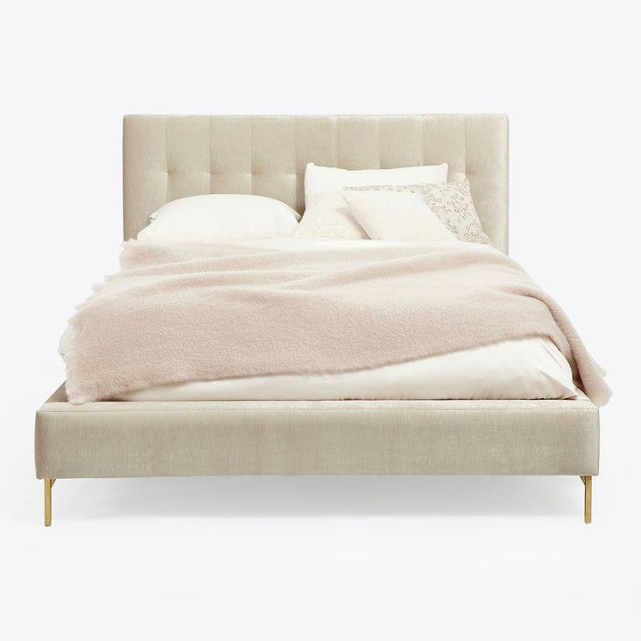 Contemporary bed with upholstered headboard and elegant metal legs.