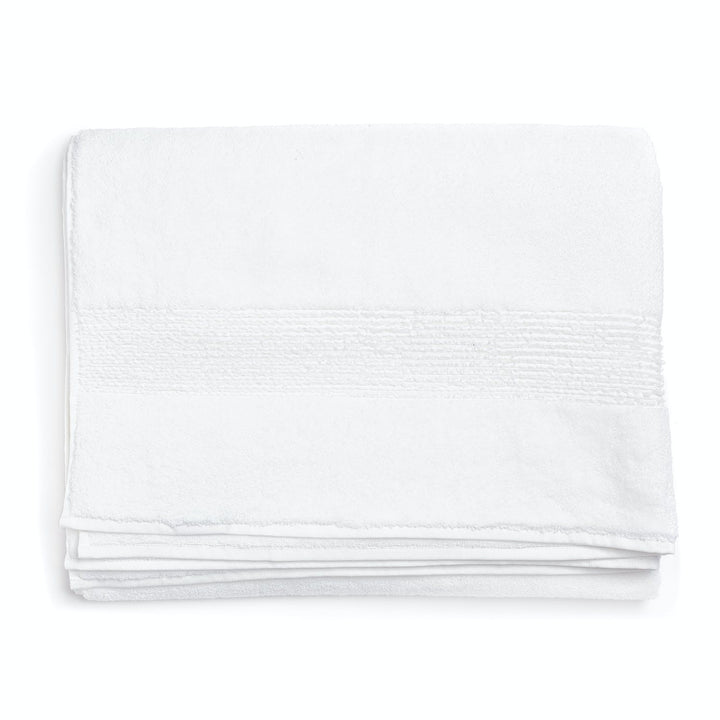 Neatly folded white towel with textured band on plain background.
