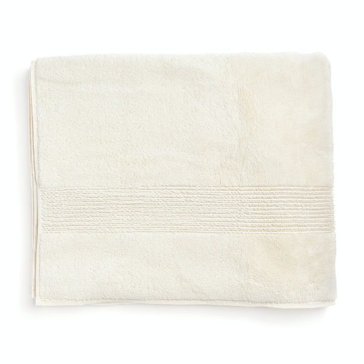 Soft and absorbent light cream towel with decorative bands folded.