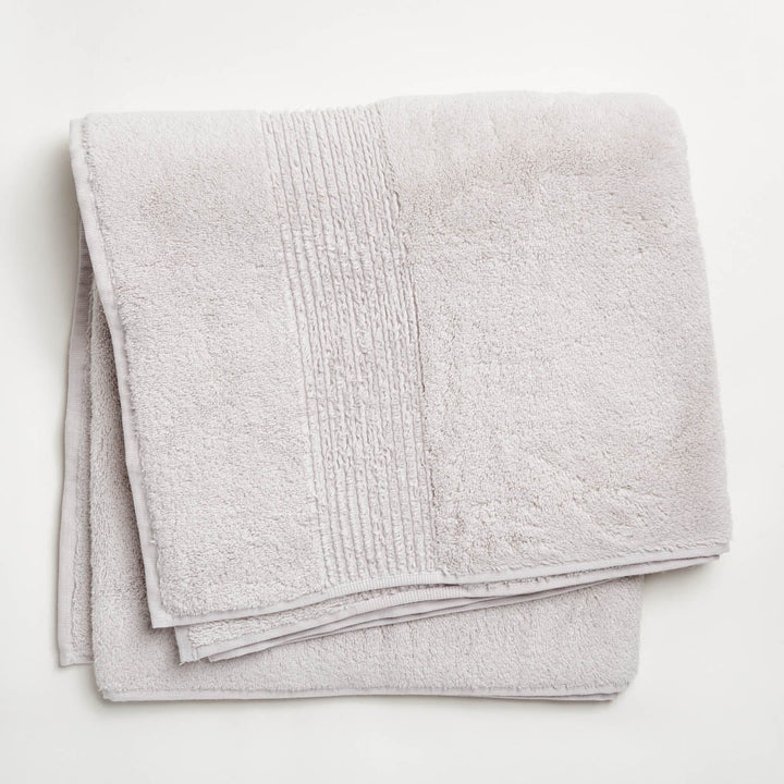 Soft and plush light-colored towel with textured ribbed design folded neatly.
