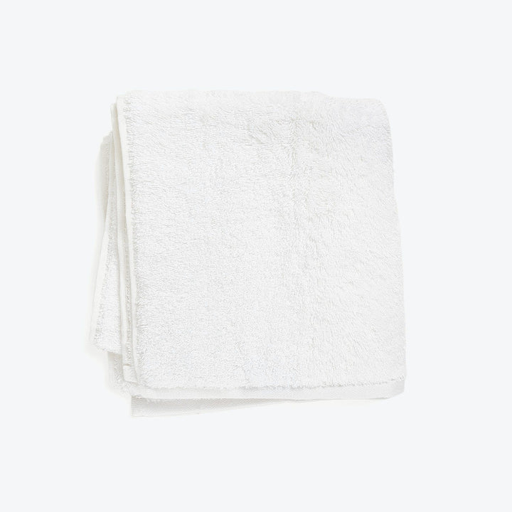 Soft, fluffy white towel against clean white background for display.
