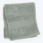 Soft, fluffy light green bath towel with decorative border folded.