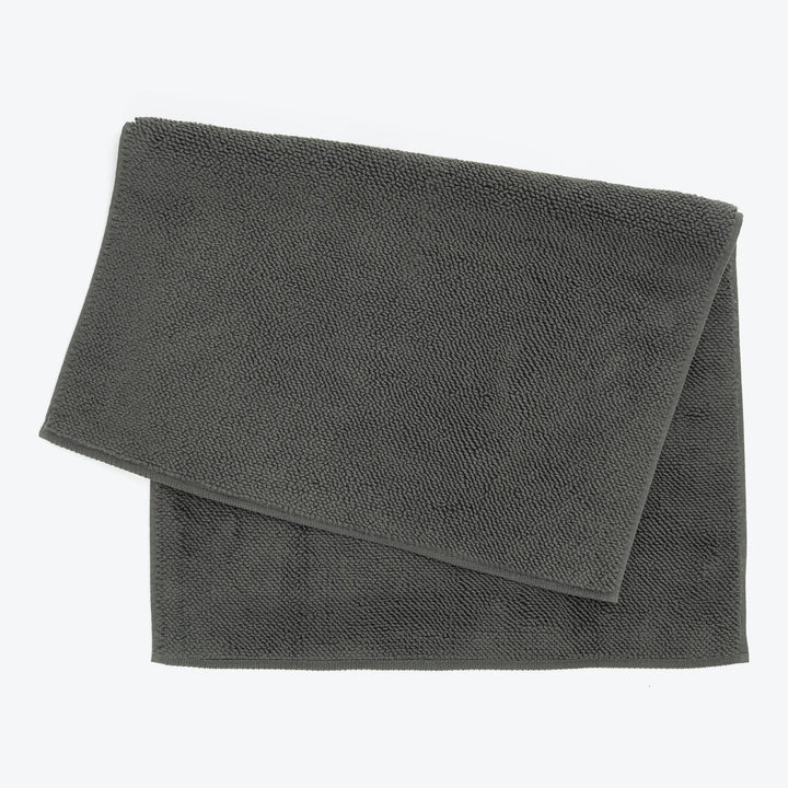 Neatly folded dark grey towels with terry cloth texture.