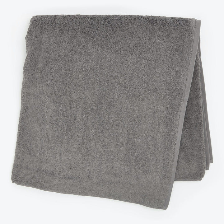 Folded gray towel with plush texture on white background.