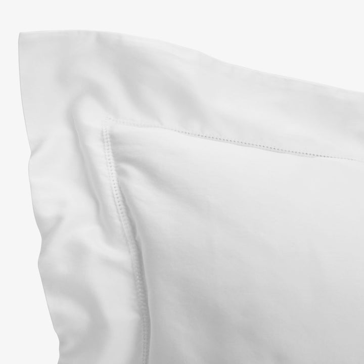 Close-up of smooth white fabric with neatly stitched seam detail.