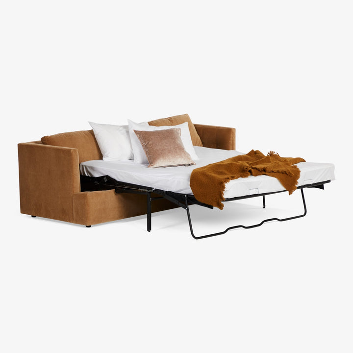 Plush brown sofa bed with pull-out mechanism and cozy bedding