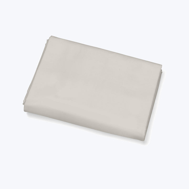 Neatly folded light fabric on plain surface, minimalistic and clean.