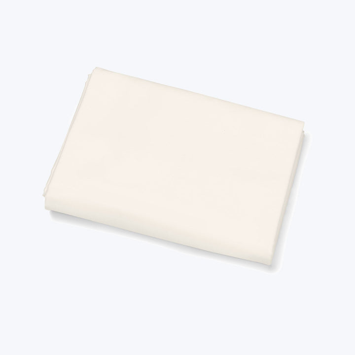 Creamy white fabric neatly folded on light background, smooth texture.