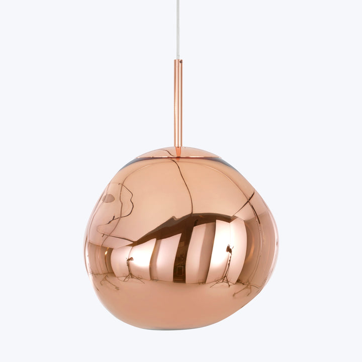 Modern, copper spherical pendant light reflecting surrounding room, elegant design.