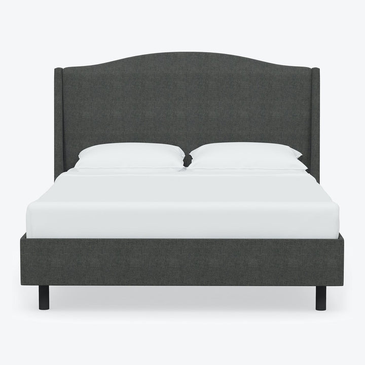 Contemporary modern bed with dark gray upholstered headboard and crisp white bedding.