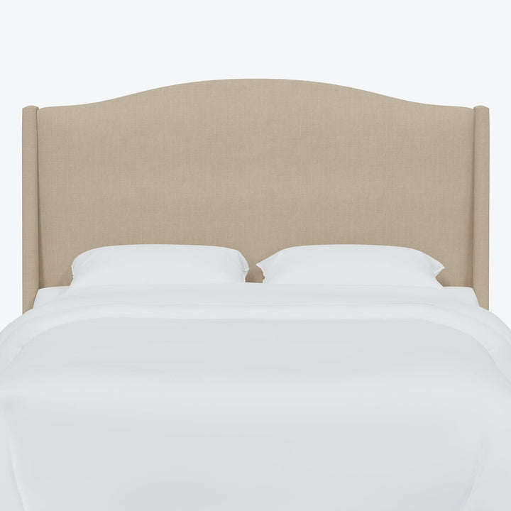 Minimalist bed with beige upholstered headboard and crisp white bedding.
