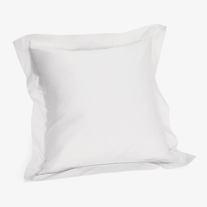 Plain white pillowcase on white background, soft cotton fabric texture