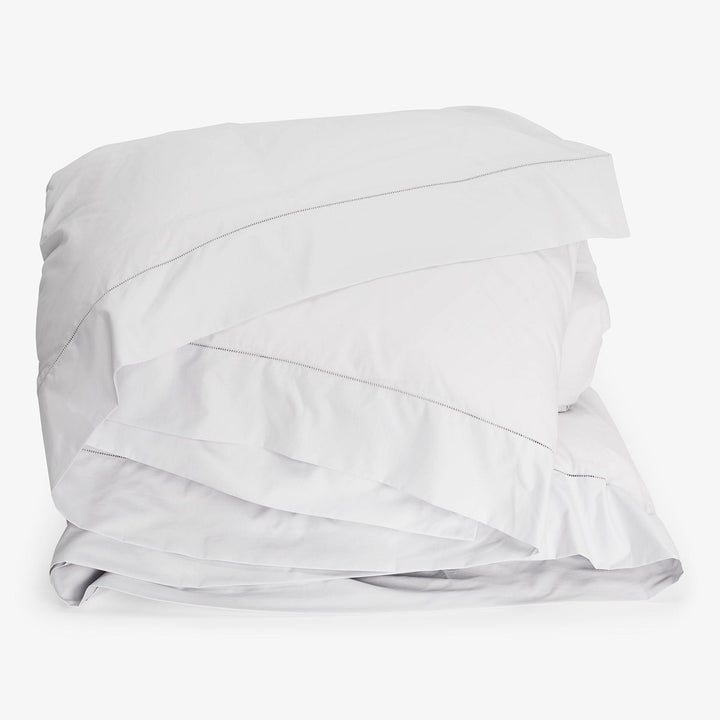 Freshly folded white bedding set, clean and crisp linens