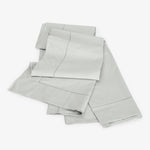 Crisp and clean light gray bed sheet set on white.