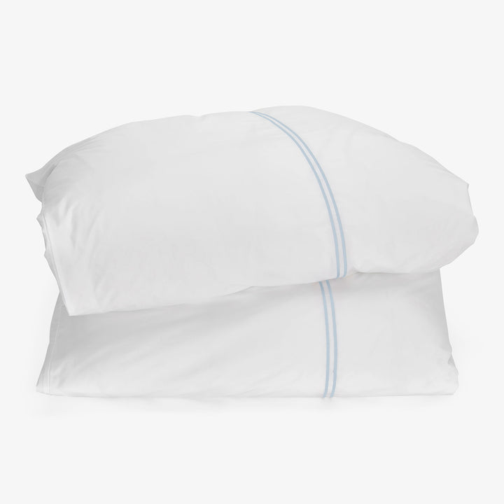 Two white pillows with blue stripe on white background.