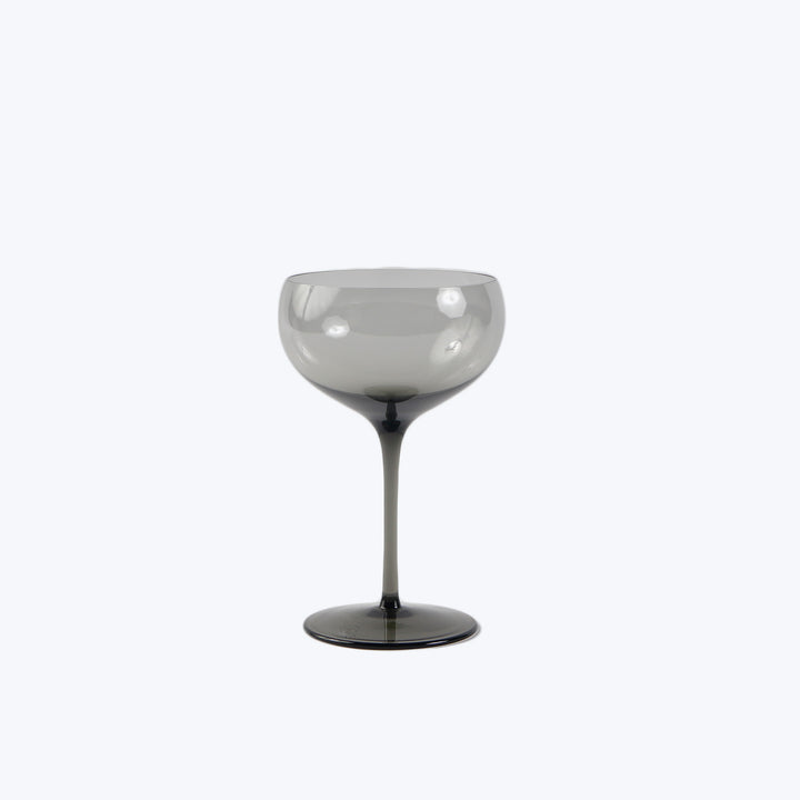 Elegant stemmed glass with smoky tint, minimalist background, polished sheen.