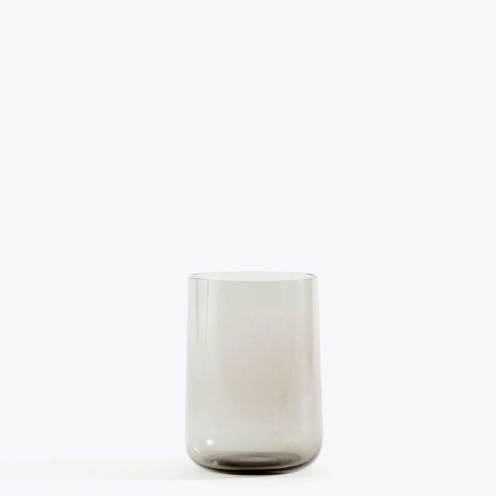 Transparent glass with cylindrical shape on plain white background surface.