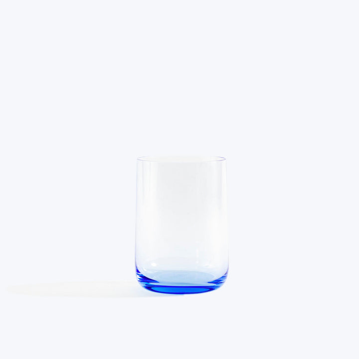 Empty blue tinted drinking glass on white background with shadow.