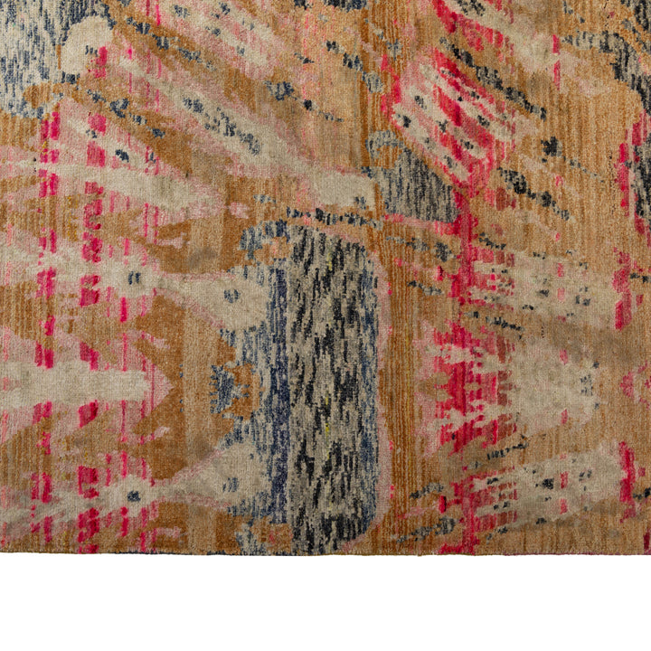 Close-up of abstract patterned rug in beige, pink, blue. Rich texture.
