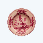 Traditional red floral ceramic plate with scalloped edge, top-down view.