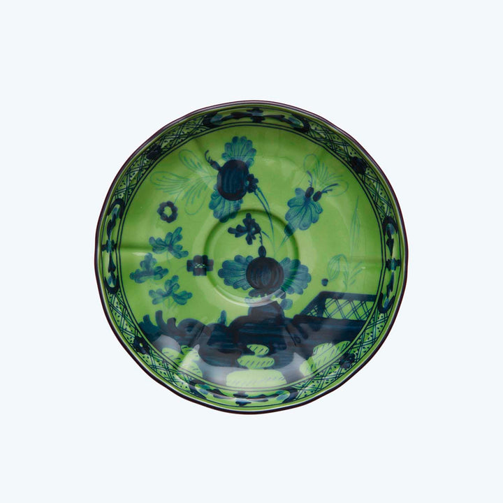 Vibrant decorative plate with blue floral pattern on green background.