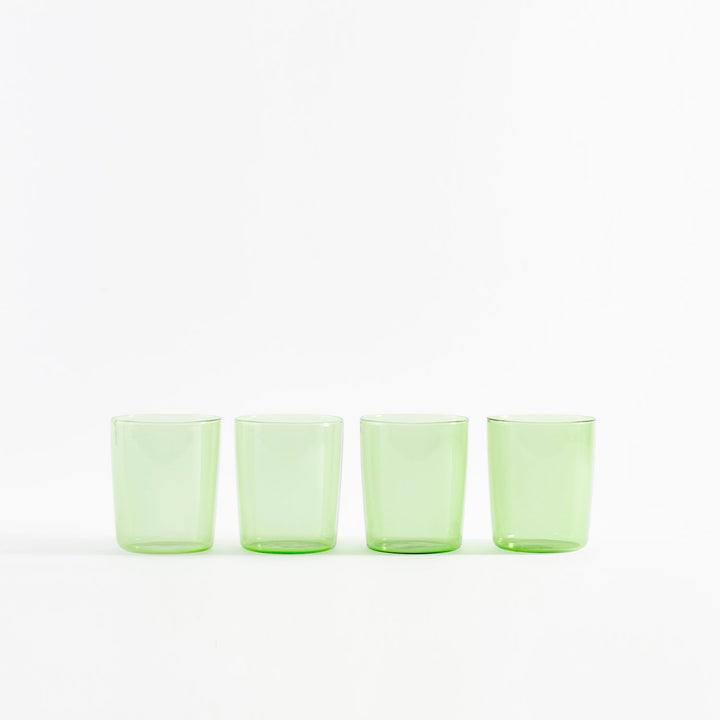 Four modern light green beverage glasses in neat row