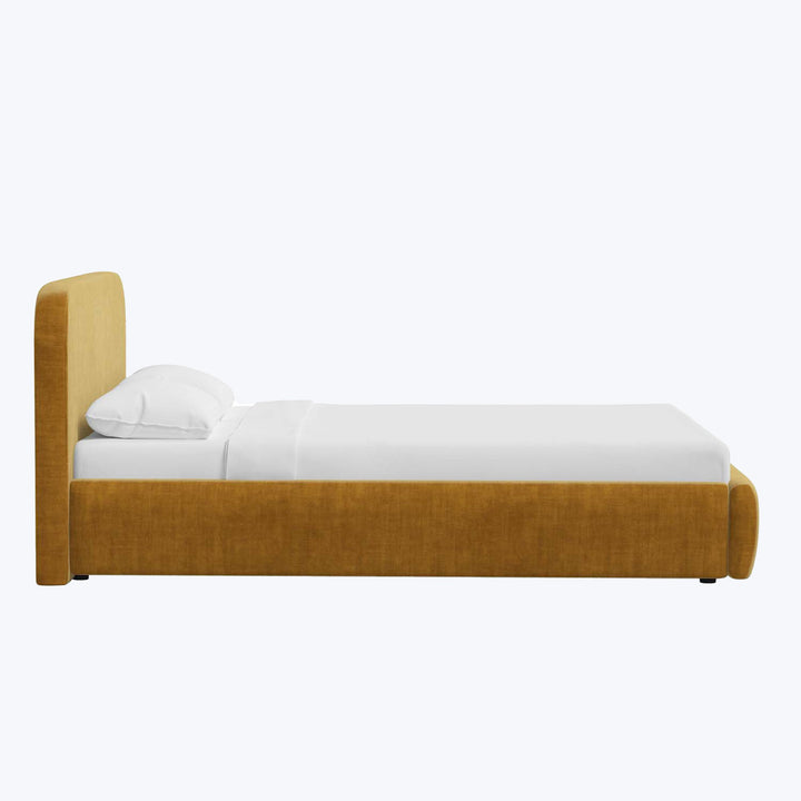 Mustard yellow upholstered single bed with white bedding, minimalist design.