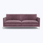 A purple two-seat sofa with sleek legs and slim track arms, upholstered in a velvet fabric.