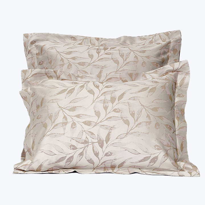 Botanical leaf patterned pillows in calming color palette for relaxation.