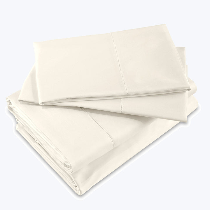 Crisp, clean, and luxurious cream-colored bed sheet set stacked neatly.