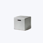 Simple concrete cube with handle slot, versatile functional design object.