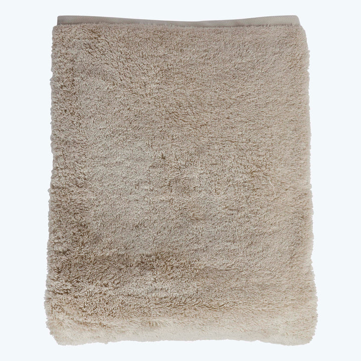 High quality plush towel in light beige color, neatly folded.