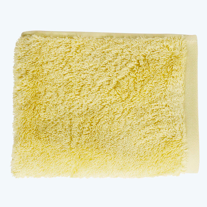 Plush yellow shaggy towel neatly folded, perfect for home decor.