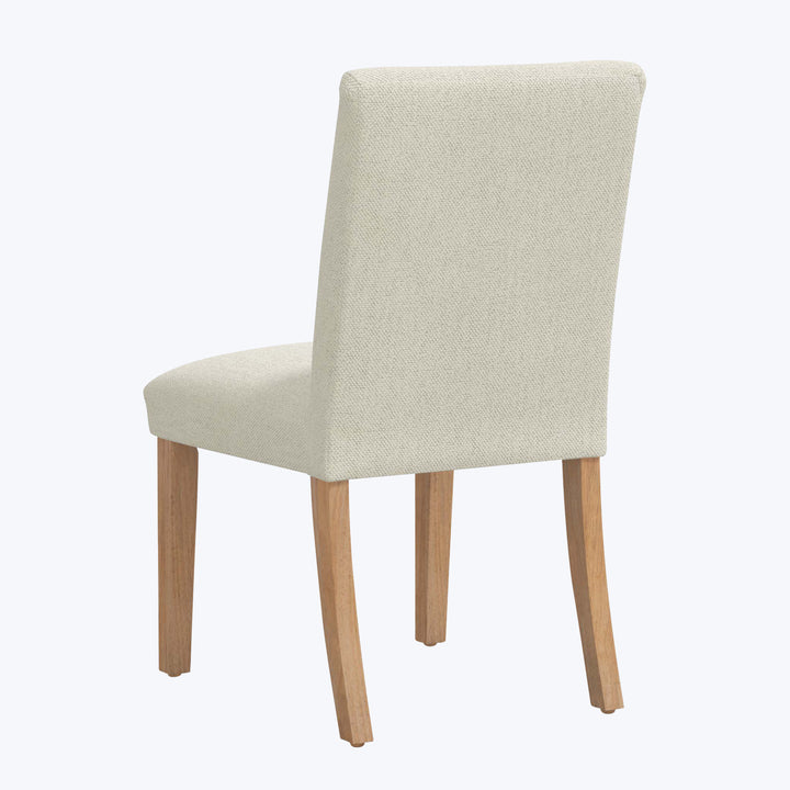 Modern dining chair with light fabric and wooden legs design.