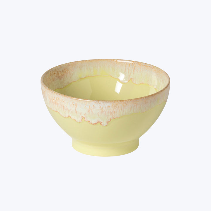 Handcrafted ceramic bowl with light yellow color and textured rim.