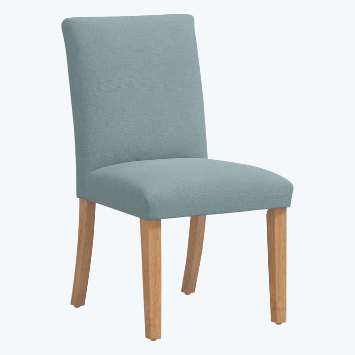 Modern dining chair with light blue upholstery and wooden legs.