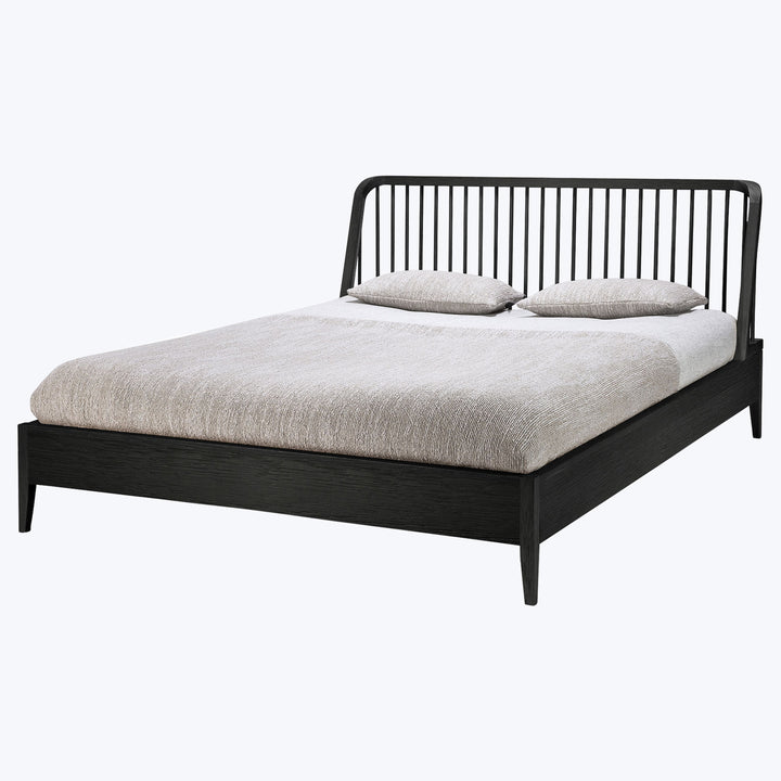 Contemporary double/queen bed with black frame and neutral bedding.
