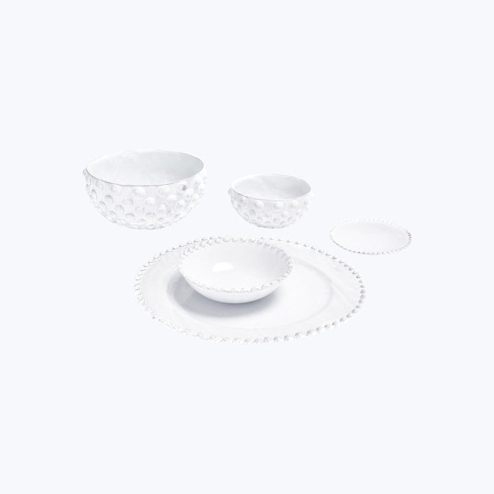 Set of white ceramic dinnerware with textured design for dining