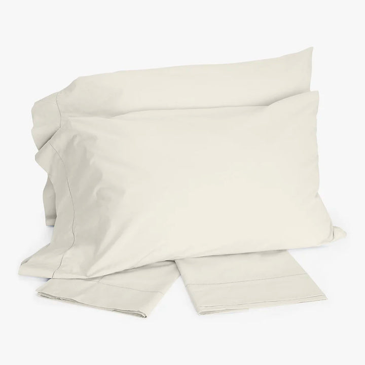 Minimalistic bedding set in soft neutral colors, folded and stacked.