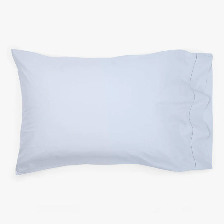 Light blue satin pillowcase on pillow with overlap closure design.