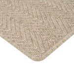 Close-up of textured beige rug with raised chevron pattern.
