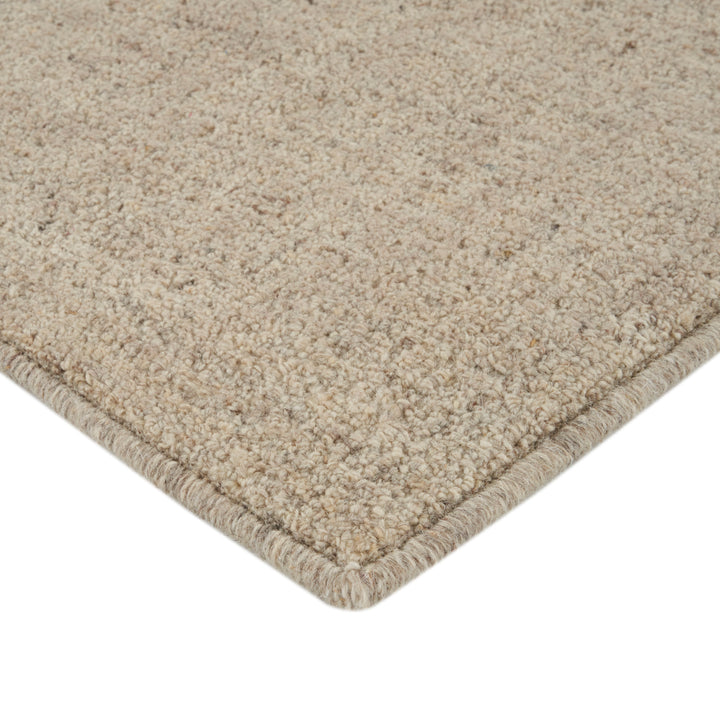 Soft, plush beige cut pile carpet with tightly edged border.