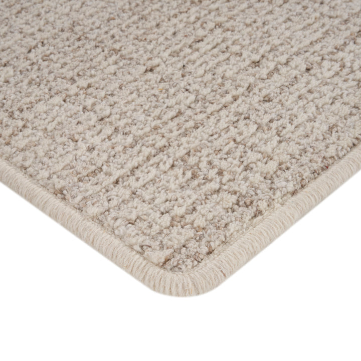 Close-up of beige heathered carpet with soft dense texture.