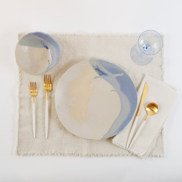 Elegant dining place setting with blue and tan marbled design.