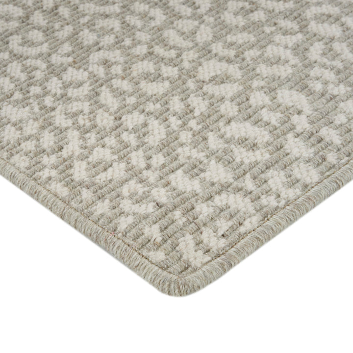 Close-up of textured rug with geometric design in neutral colors.
