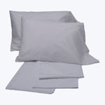 Simple and elegant light grey bed linens on white background.