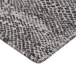 Close-up of houndstooth pattern on textured fabric, black and white.